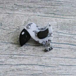 Brož černo-bílý ptáček s pohyblivými nožičkami